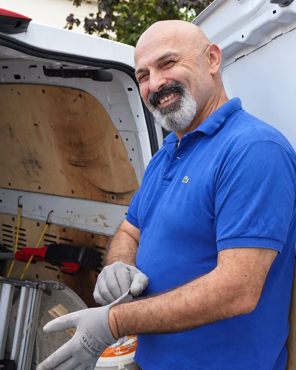 Zafer Sen zieht vor seinem Transporter die Arbeitshandschuhe an